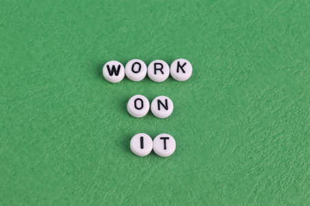 Alphabet letters with text WORK ON IT isolated on a green background