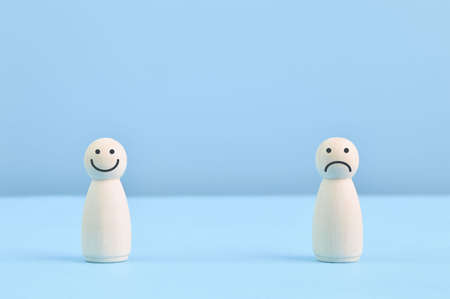 Wooden doll figures with smile and sad face. Customer evaluation and satisfaction conceptの写真素材