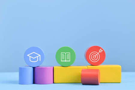Colorful wooden blocks with graduation cap, book and dart symbols. Success concept.の写真素材