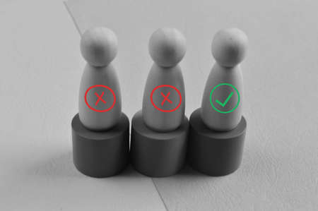 Wooden doll figures with wrong and green marks. The best choice concept