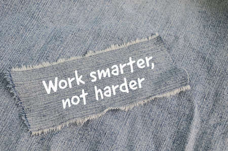 Ripped blue jeans written with text WORK SMARTER, NOT HARDERの写真素材