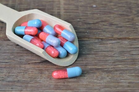 Group of medical pill capsules on wooden table