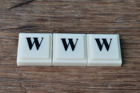 Square letters on wooden background with text WWWの写真素材