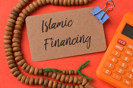 Calculator, prayer beads and brown card with text ISLAMIC FINANCING