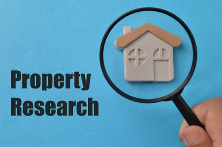 Toy house and magnifying glass with text PROPERTY RESEARCHの写真素材