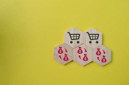 Wooden hexagon with shopping cart and money symbols.