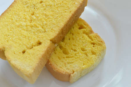 Sliced of bread with butter on a white plate