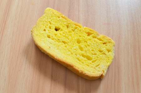 Slice of bread with butter on a wooden table
