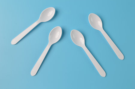 Plastic spoons isolated on a blue backgroundの写真素材