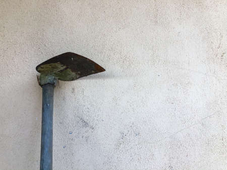 Hoe for gardening laid on wall. Copy space.