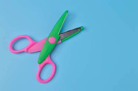 Scissors isolated on a blue background. School and office suppliesの写真素材