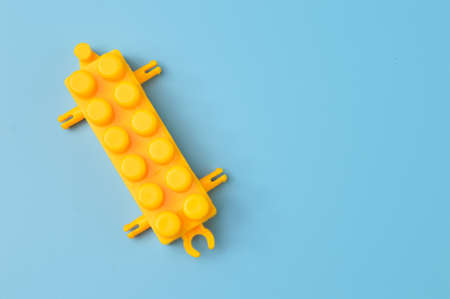 Toy building block isolated on a blue background. Copy space for the text