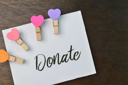 wooden clips and white paper written with DONATEの写真素材