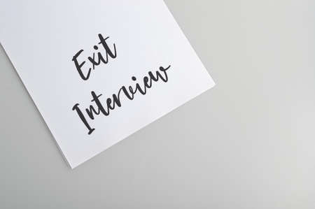 White paper written with text EXIT INTERVIEW isolated on a grey backgroundの写真素材