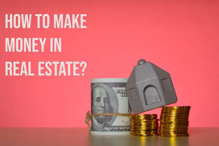 Stack of coins, money banknotes and toy house with question HOW TO MAKE MONEY IN REAL ESTATE?の写真素材