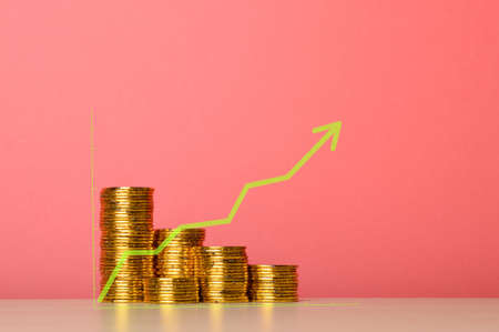 Stack of gold coins and green arrow up symbol