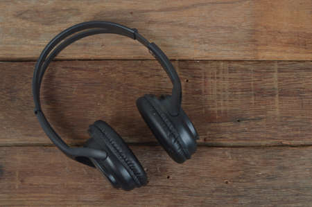 Black headphone isolated on a wooden backgroundの写真素材