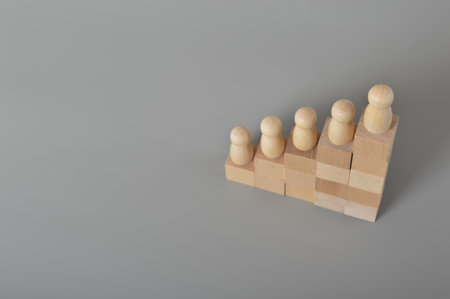 Wooden people of figures standing on wooden block steps. Career growth, leadership, development and goal achievement.の写真素材