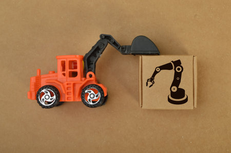 Construction loader tractor toy and cardboard box with smart industry symbol.