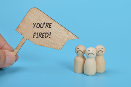 Sad wooden figure of people with text YOU'RE FIRED!の写真素材