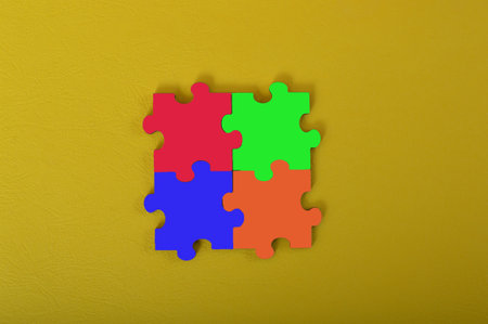 Colorful jigsaw puzzle isolated on a yellow background. Copy space for the text.の写真素材
