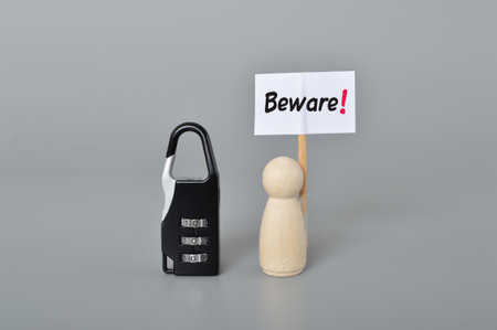 Padlock and wooden people with text BEWARE!. Security and protection concept