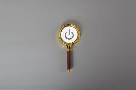 A round power button represent On and Off . The switch is placed on a grey background.