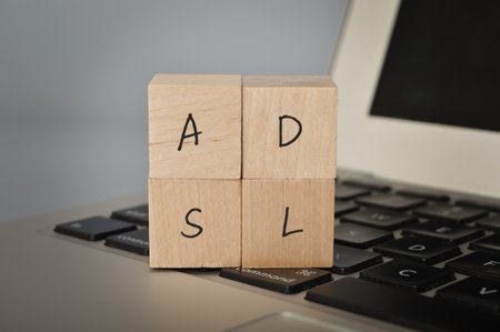 Wooden cube block with text ADSL. ADSL stands for "Asymmetric Digital Subscriber Line". It is a type of internet connection technology that allows data to be transmitted over traditional copper telephone lines.の写真素材