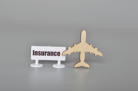 Airplane and plastic board with text INSURANCE.Concept of travel insuranceの写真素材