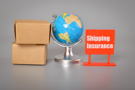 World globe, cardboard boxes and plastic board with text SHIPPING INSURANCE.の写真素材