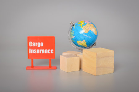 World globe, wooden blocks and plastic board with text CARGO INSURANCE.の写真素材