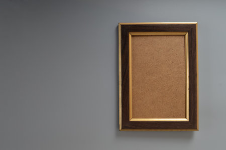 Empty horizontal brown frame mockup. Set within a stylish modern minimalist interior, against a backdrop of elegant grey, this template provides the ideal canvas to bring your artistic vision to life.の写真素材