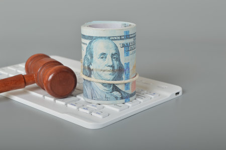 Money, judge gavel and computer keyboard.The Internet Crime concept casts a shadow over the realm of internet auctions, necessitating heightened vigilance and robust security measures to safeguard users from the ever-evolving tactics employed by cybercriminals in their attempts to deceive and defraudの写真素材