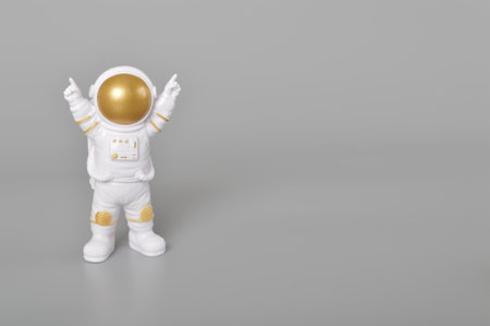 Astronaut toy in action isolated on a grey background.の写真素材