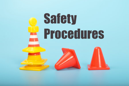 Yellow and red traffic cones with text SAFETY PROCEDURESの写真素材
