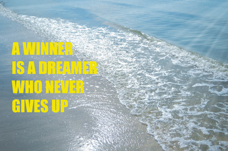 Motivational quote written with A WINNER IS A DREAMER WHO NEVER GIVES UPの写真素材