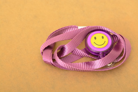 The close-up view highlights a purple ID card with a smiley lanyard