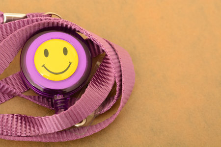 The close-up view highlights a purple ID card with a smiley lanyardの写真素材