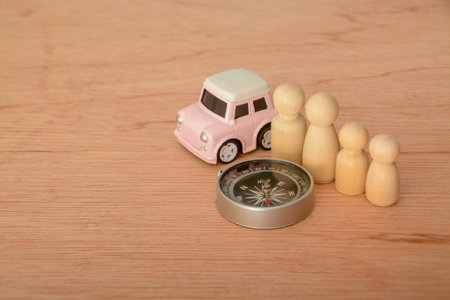 Toy car, compass and family figures. Travel concept