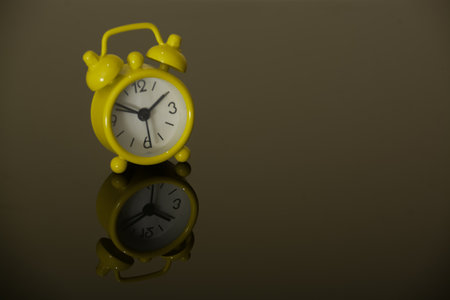 Yellow alarm clock isolated on a black backgroundの写真素材