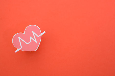 Heart beat isolated on a red background. symbolize routine medical check-ups, diagnostics, and the importance of heart health examinationsの写真素材