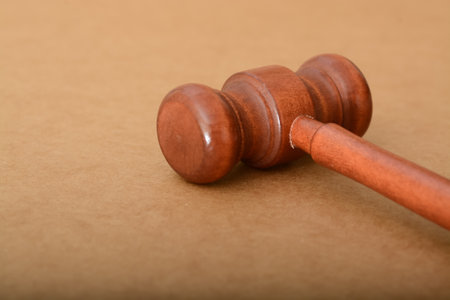 Brown judge gavel isolated on a brown background with copy spaceの写真素材
