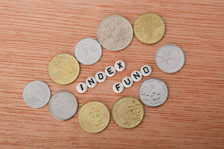 Coins and alphabet beads with text INDEX FUND. An index fund is a type of mutual fund or...