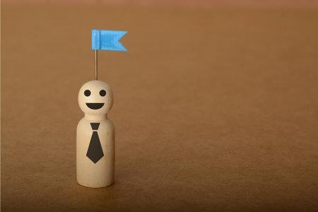 The triumphant businessman raised his flag high in the air, a symbol of his hard-earned success and unwavering dedication to his targetの写真素材