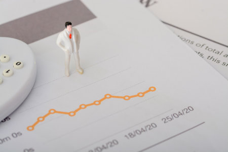 The businessman spent hours meticulously looking at the sales graph, seeking patterns and insights to optimize business strategiesの写真素材