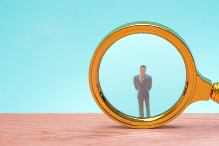 The astute businessman employed a magnifying glass to delve into the financial reports, seeking opportunities for growthの写真素材