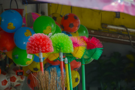 Household brooms come in various styles, including plastic brooms found on the shelves of a shopの写真素材
