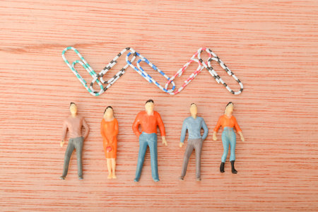 A group of people standing together, with paper clips serving as a symbol of unity and teamwork.の写真素材