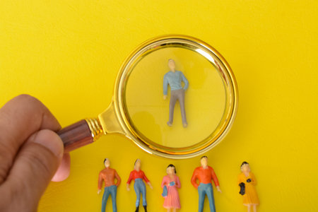 Using a magnifying glass, the staff meticulously combed through the resumes, searching for the perfect fit to hire for the job.の写真素材