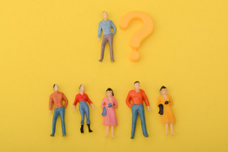 The question mark symbol, isolated on a yellow background, draws the attention of a diverse group of...